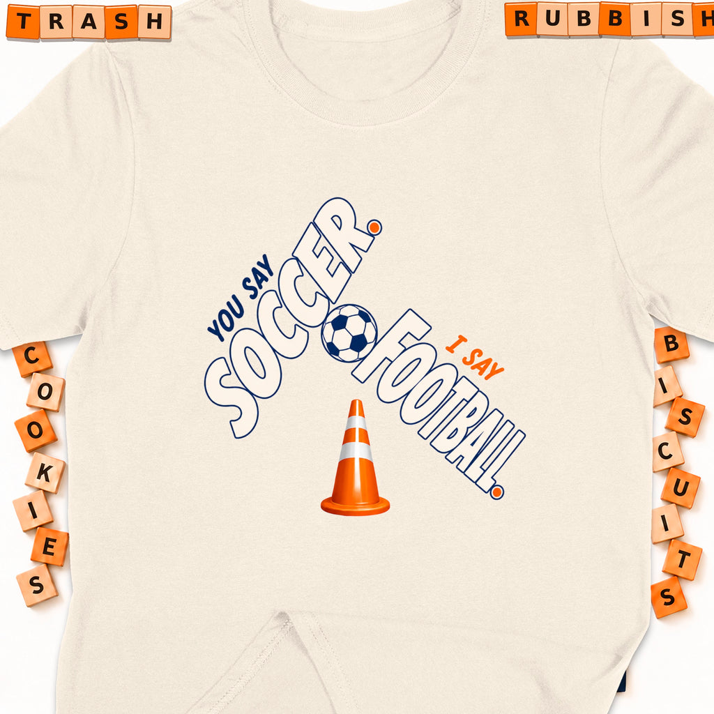 Cream t-shirt with "You Say Soccer, I Say Football" graphic and traffic cone.