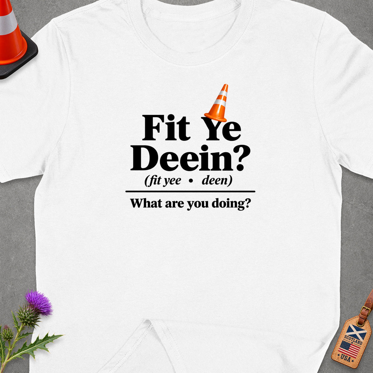 White t-shirt with "Fit Ye Deein?" text and an orange traffic cone.