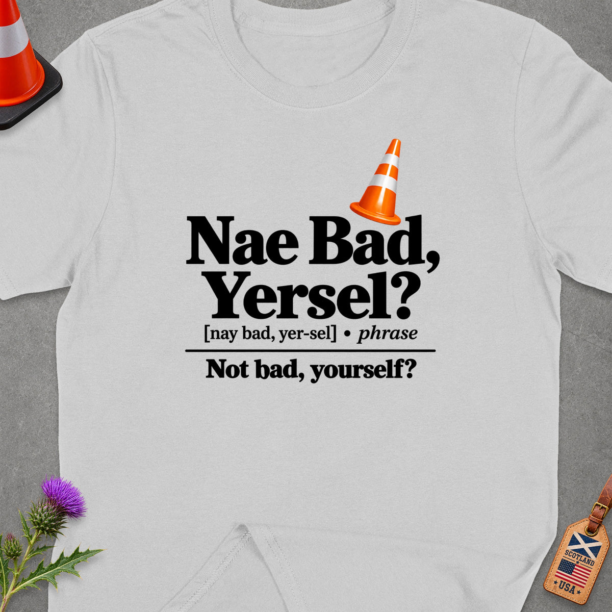 White t-shirt with black text "Nae Bad, Yersel? Not bad, yourself?" and a traffic cone.