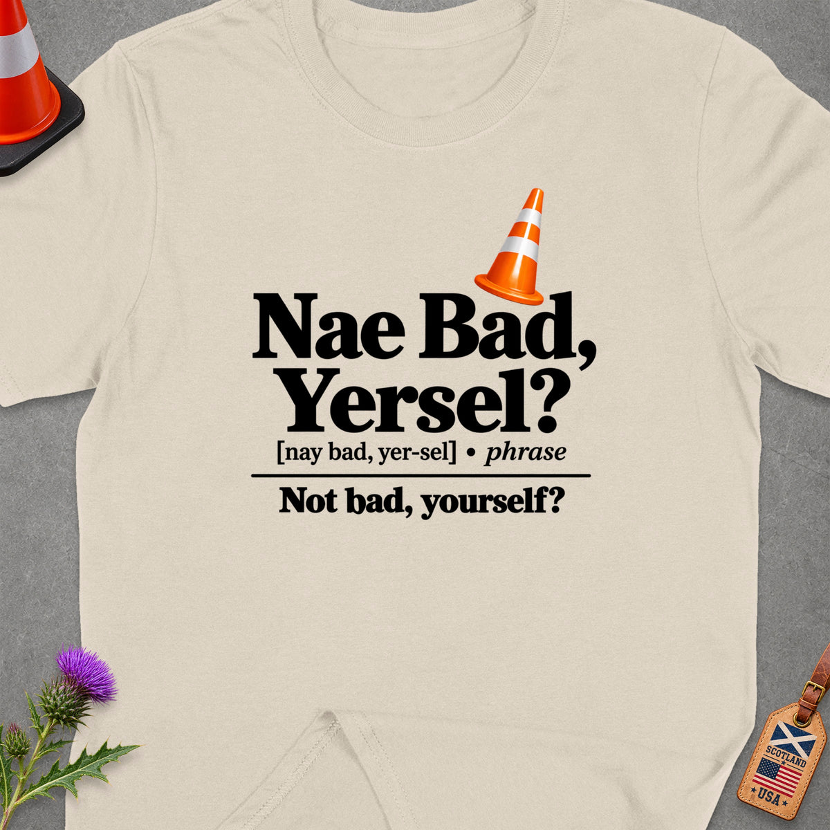 Cream t-shirt with "Nae Bad, Yersel?" text and orange traffic cone.