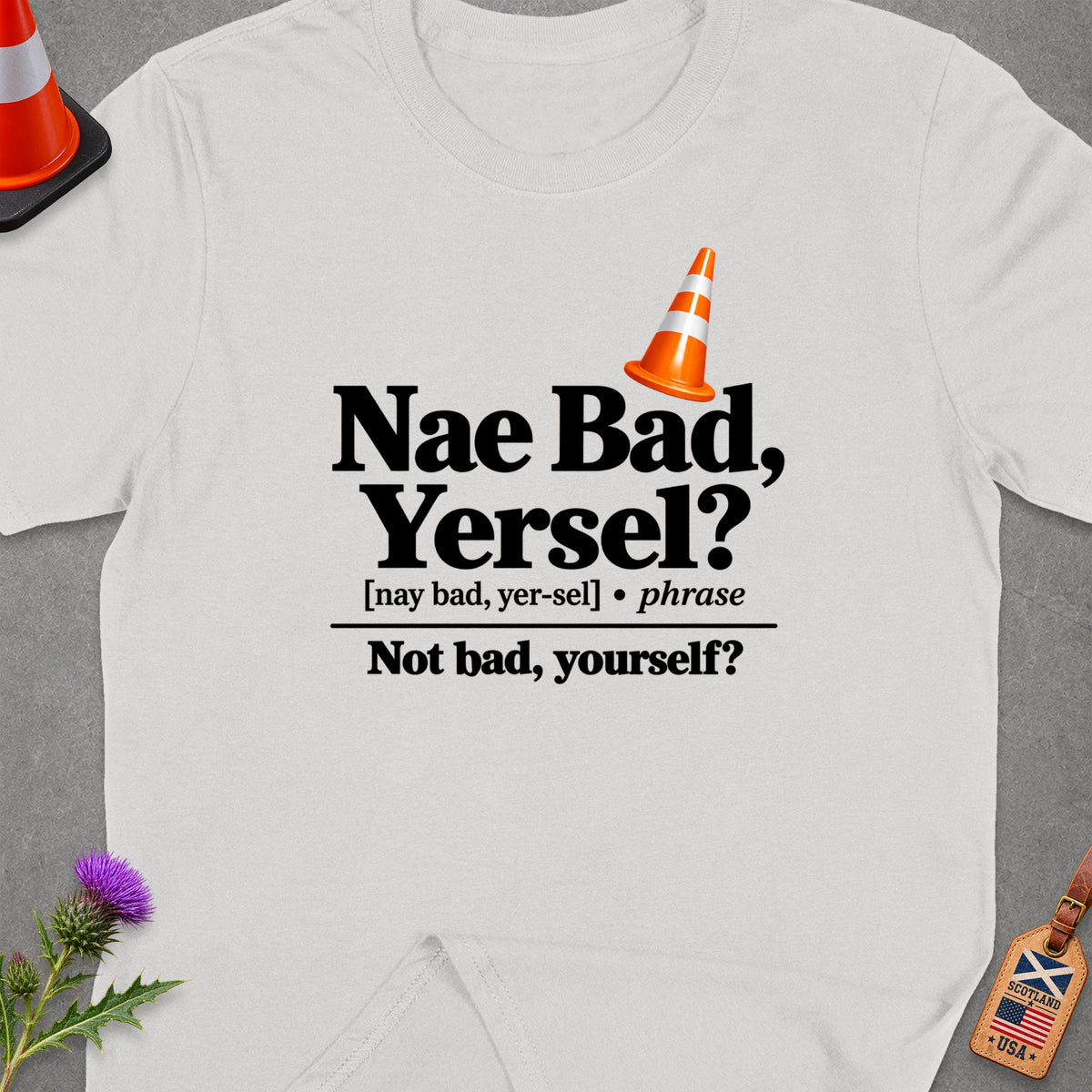 White t-shirt with "Nae Bad, Yersel?" text and a traffic cone graphic.