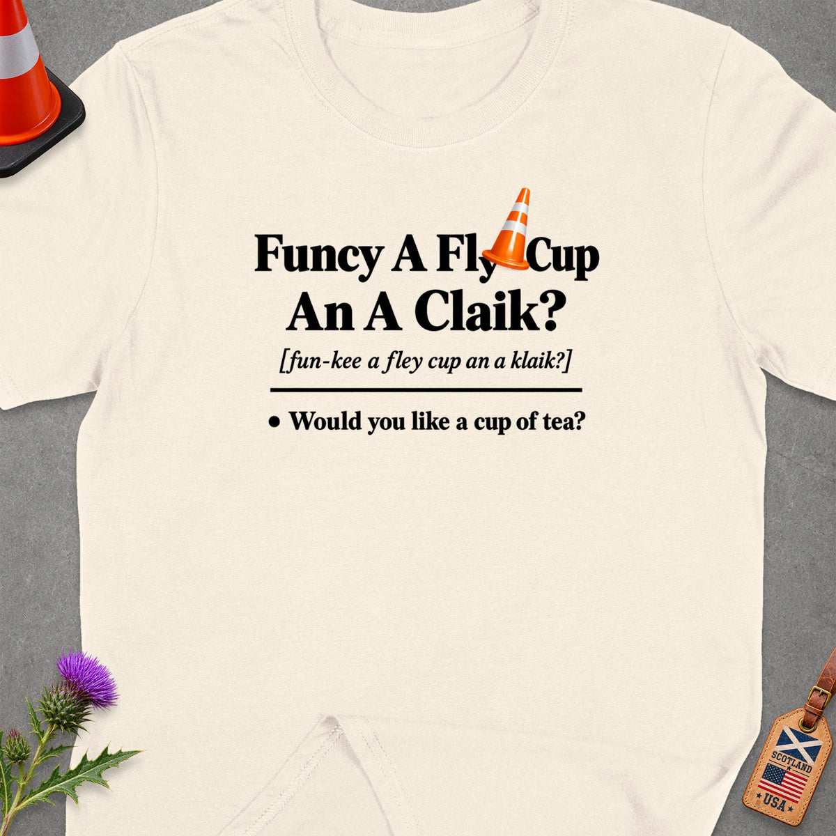 Cream t-shirt with Scottish phrase "Funcy A Fly Cup An A Claik?" and "Would you like a cup of tea?".