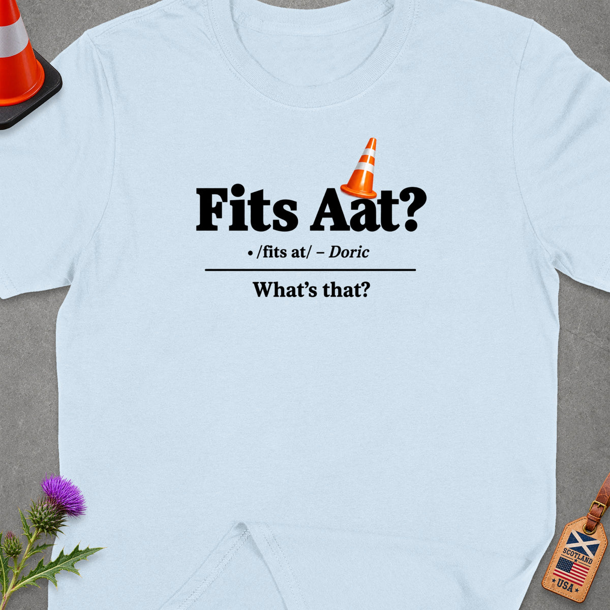 Light blue t-shirt with "Fits Aat? /fits at/ – Doric What's that?" text and orange cone graphic.