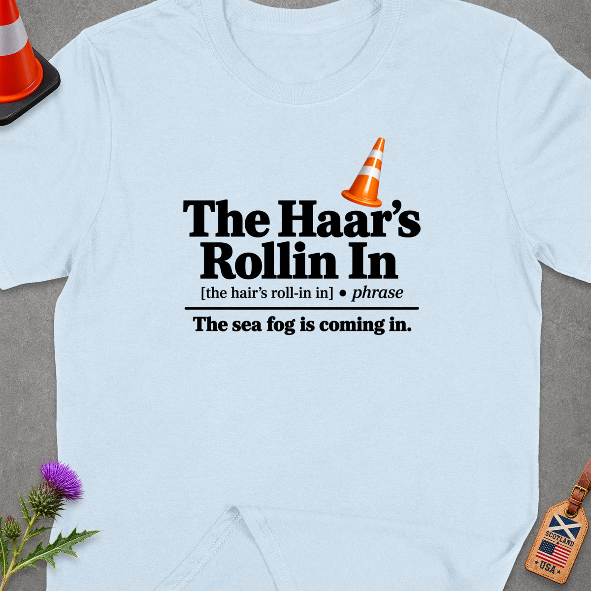 Light blue t-shirt with "The Haar's Rollin In" text and traffic cone.