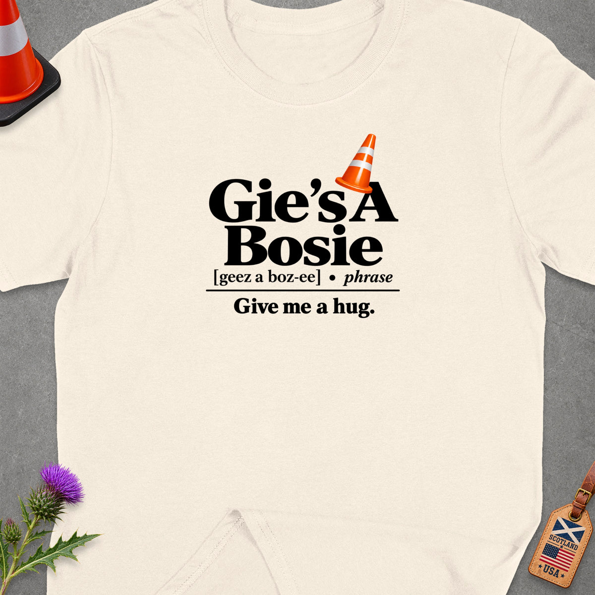 Cream t-shirt with "Gie's A Bosie Give me a hug" text and orange cone.