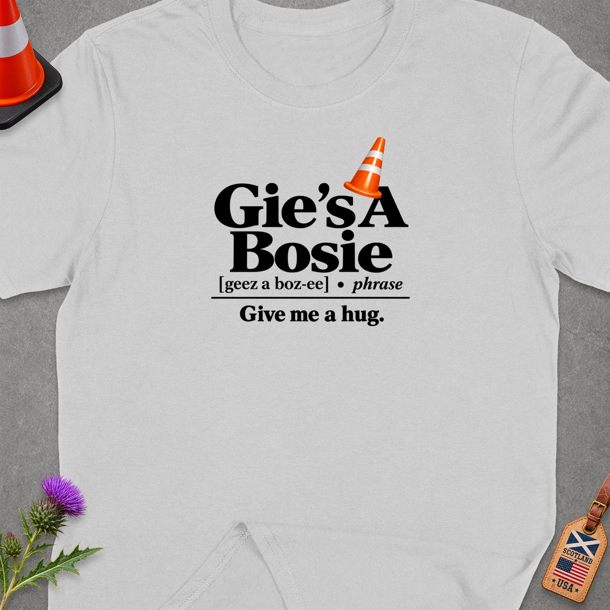 White t-shirt with "Gie's A Bosie, Give me a hug." text and orange traffic cone graphic.