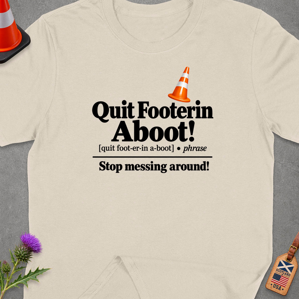 Cream t-shirt with black text reading "Quit Footerin Aboot!" and "Stop messing around!".