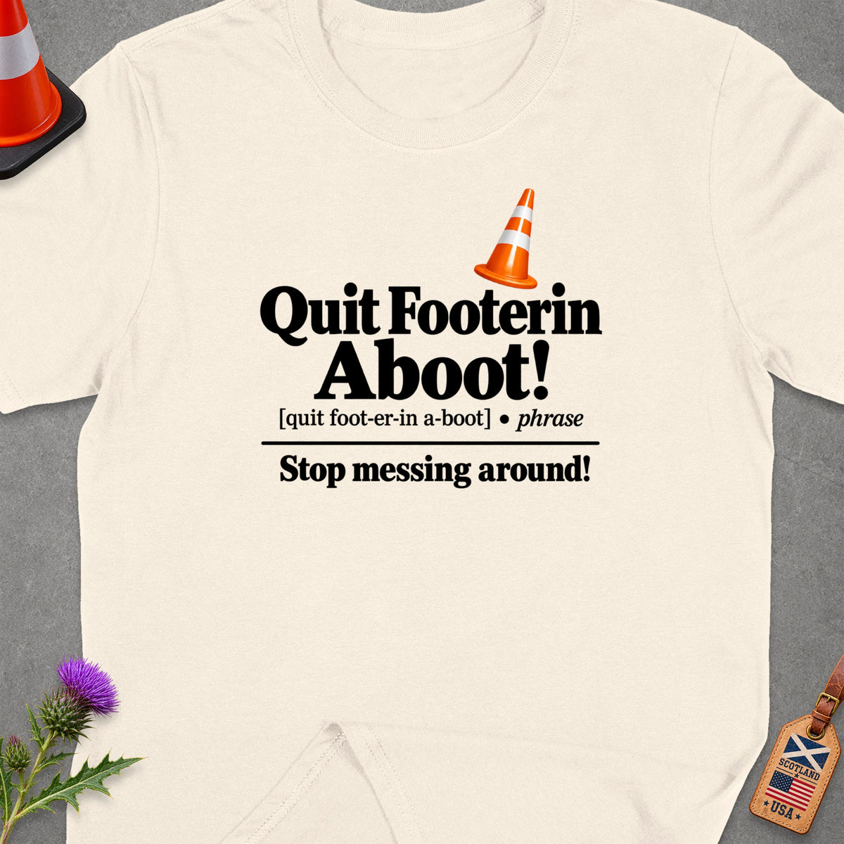 Cream t-shirt with "Quit Footerin Aboot! Stop messing around!" text.