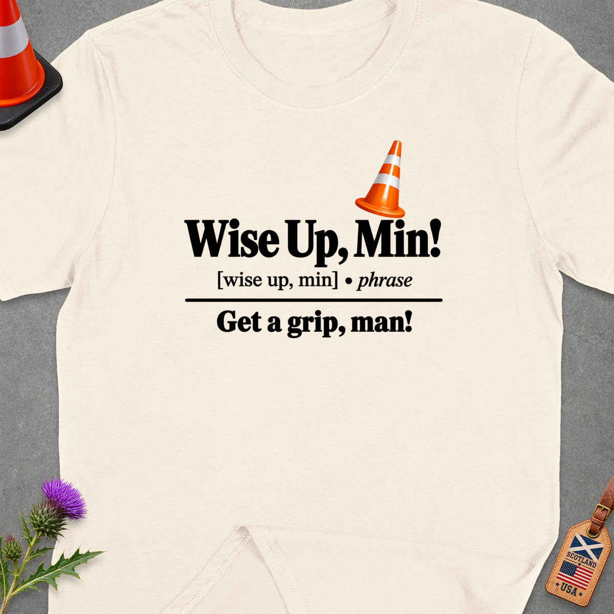 Cream t-shirt with "Wise Up, Min! Get a grip, man!" text and a traffic cone.