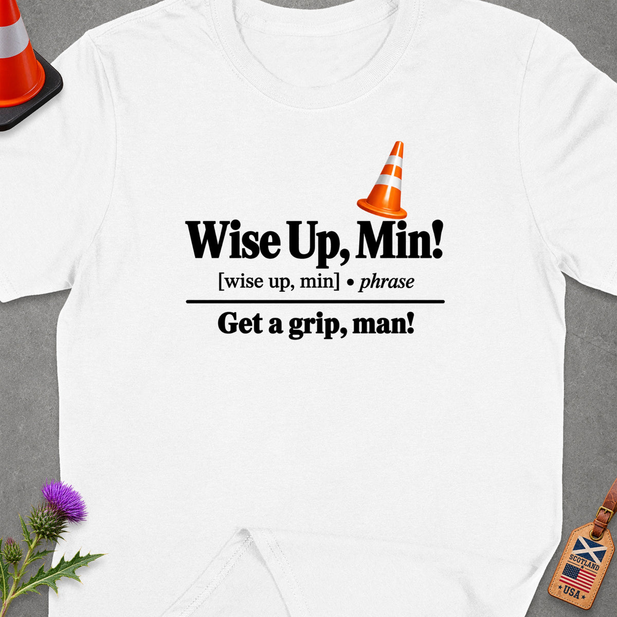 White t-shirt with text "Wise Up, Min! Get a grip, man!" and a traffic cone.