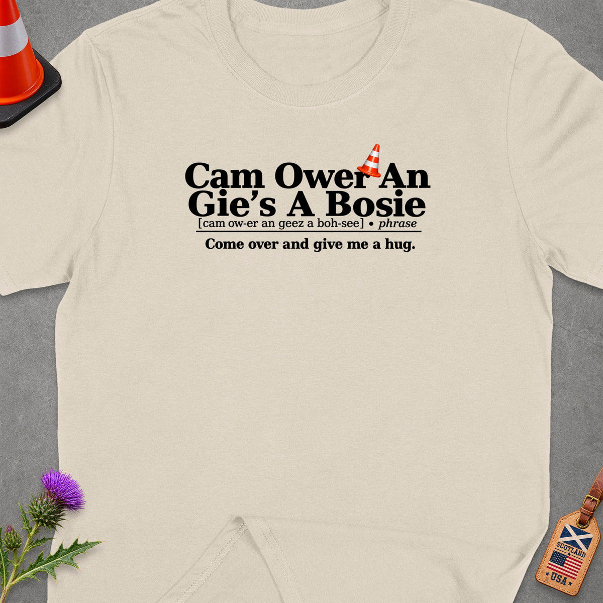 Cream t-shirt with Scottish phrase "Cam Ower An Gie's A Bosie" and translation.