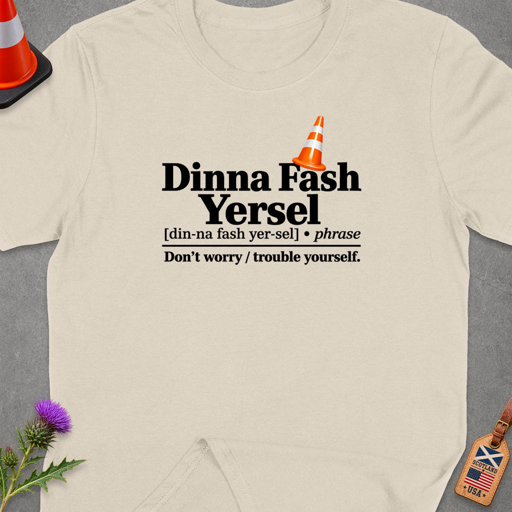 Cream t-shirt with "Dinna Fash Yersel" text and Scottish-American flag tag.