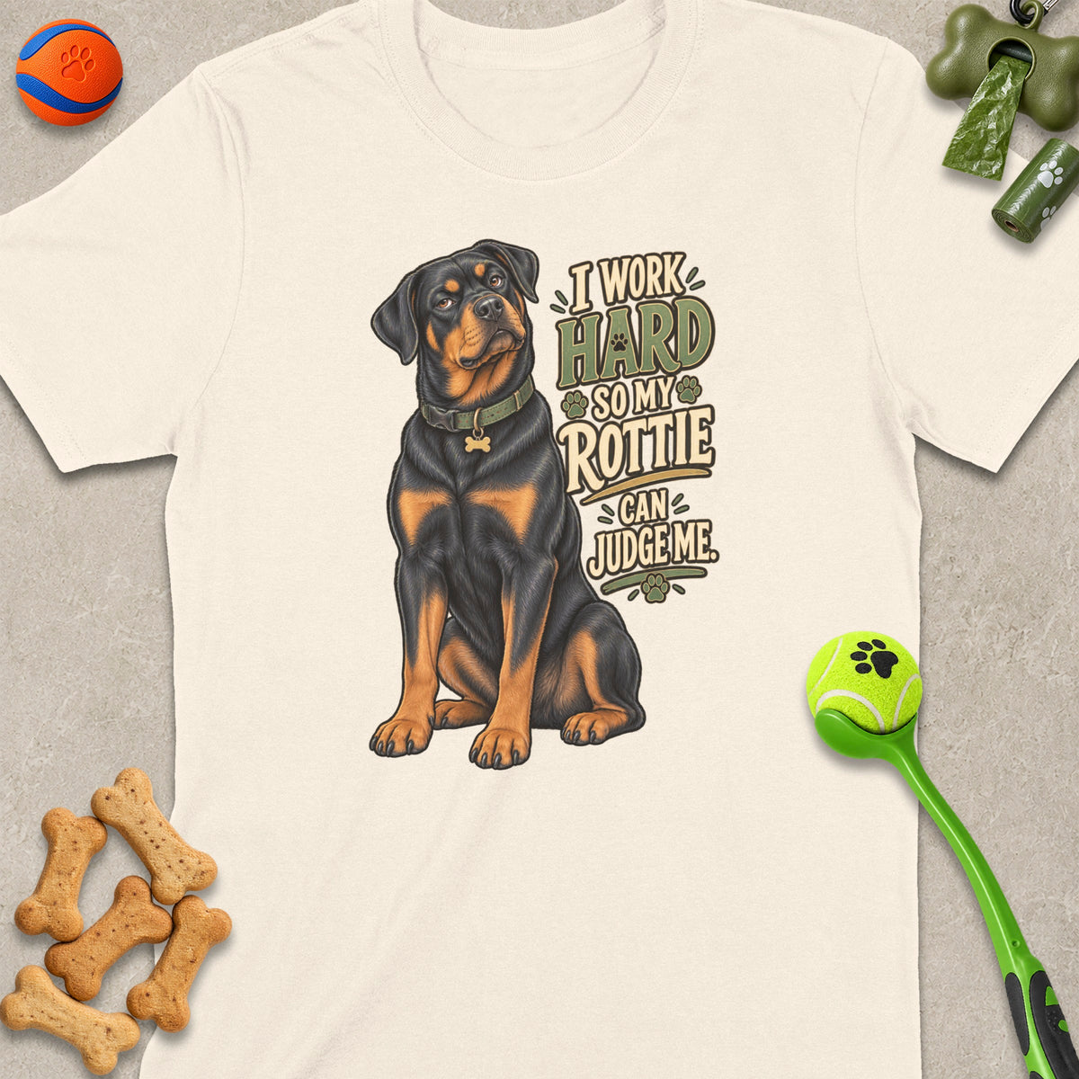 Rottweiler illustration on a cream t-shirt with text "I Work Hard So My Rottie Can Judge Me".