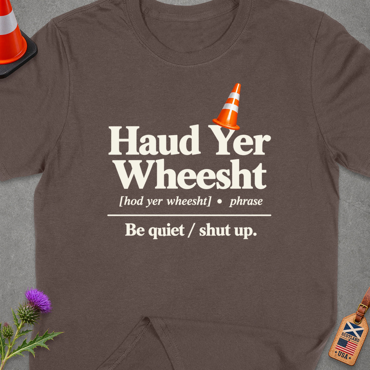Brown t-shirt with "Haud Yer Wheesht" and definition, orange traffic cone graphic.