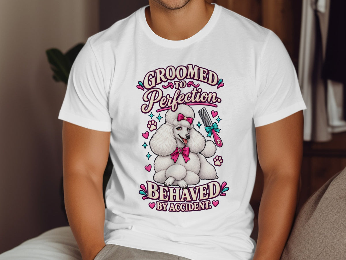 White t-shirt with a poodle graphic and text: "GROOMED TO Perfection. BEHAVED BY ACCIDENT."