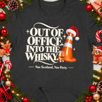 Dark t-shirt with "Out of Office Into the Whisky" text and Christmas decor.