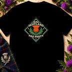 A black t-shirt featuring a diamond-shaped emblem with an orange thistle and the text Nae Scotland Nae Party.
