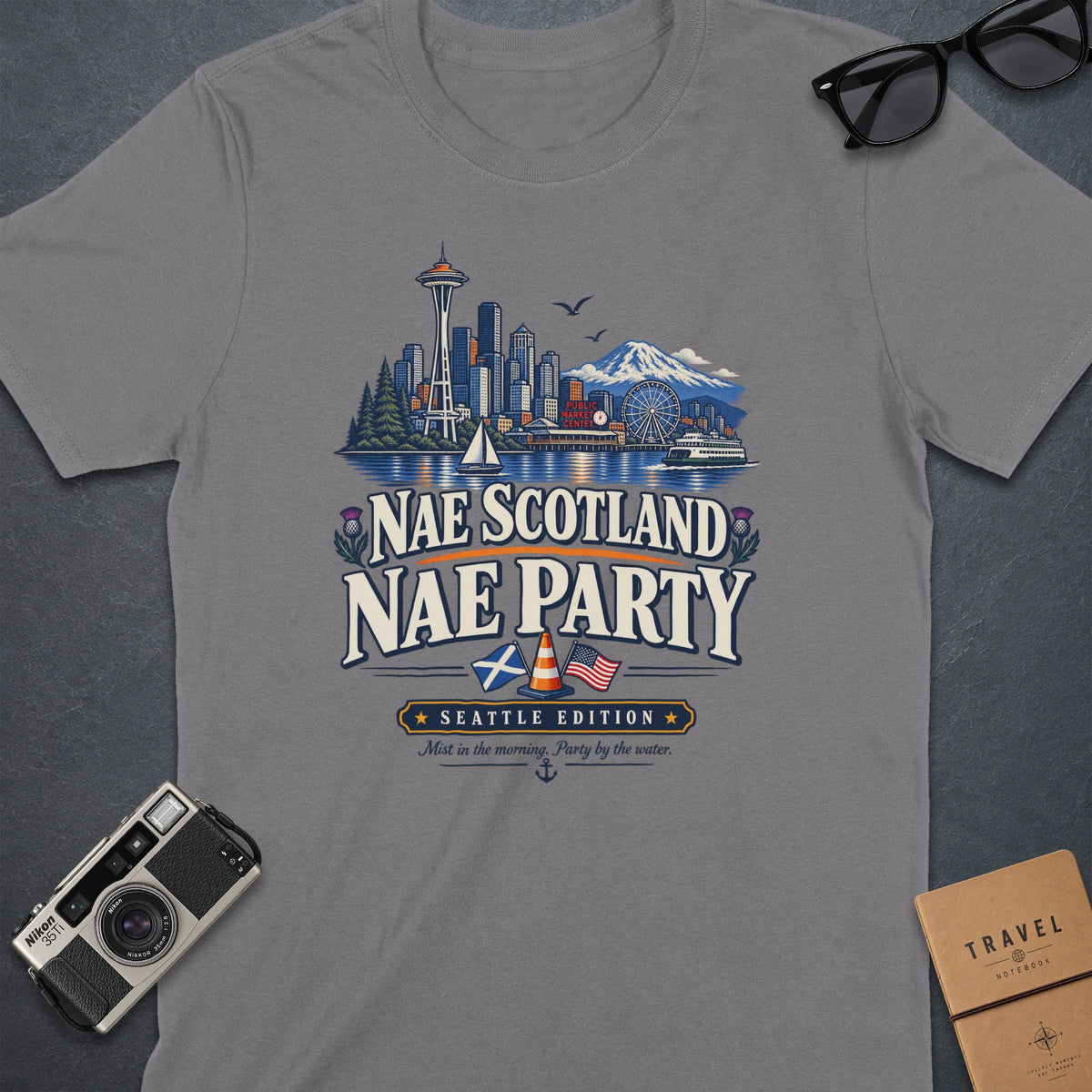 Grey t-shirt featuring Seattle skyline art and "Nae Scotland Nae Party Seattle Edition" text.