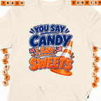Cream t-shirt with "You Say Candy, I Say Sweets" text and traffic cone graphic.