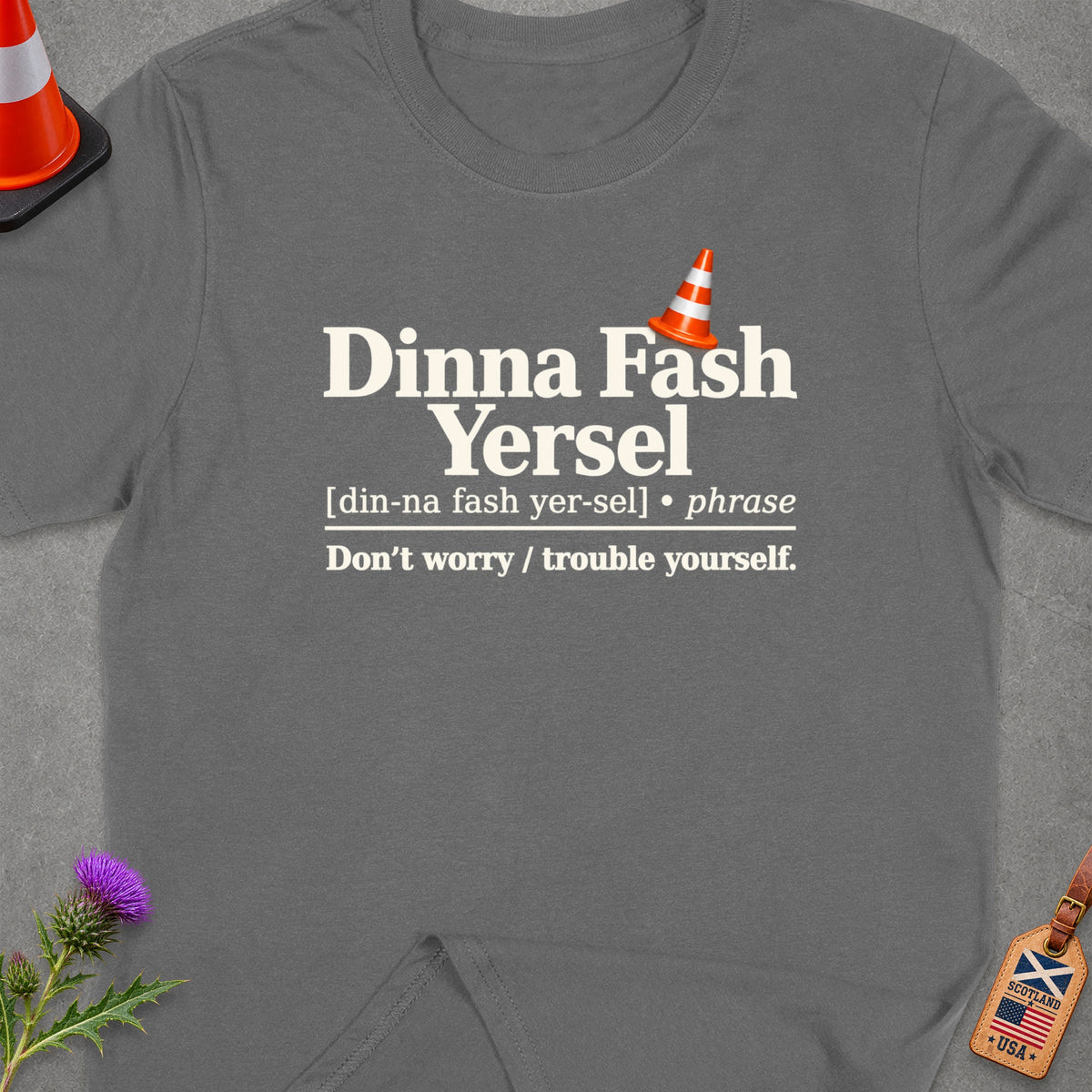 Gray t-shirt with Scottish phrase "Dinna Fash Yersel" and its English translation.