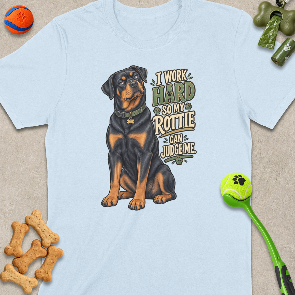 Light blue t-shirt with Rottweiler graphic and text "I work hard so my rottie can judge me."