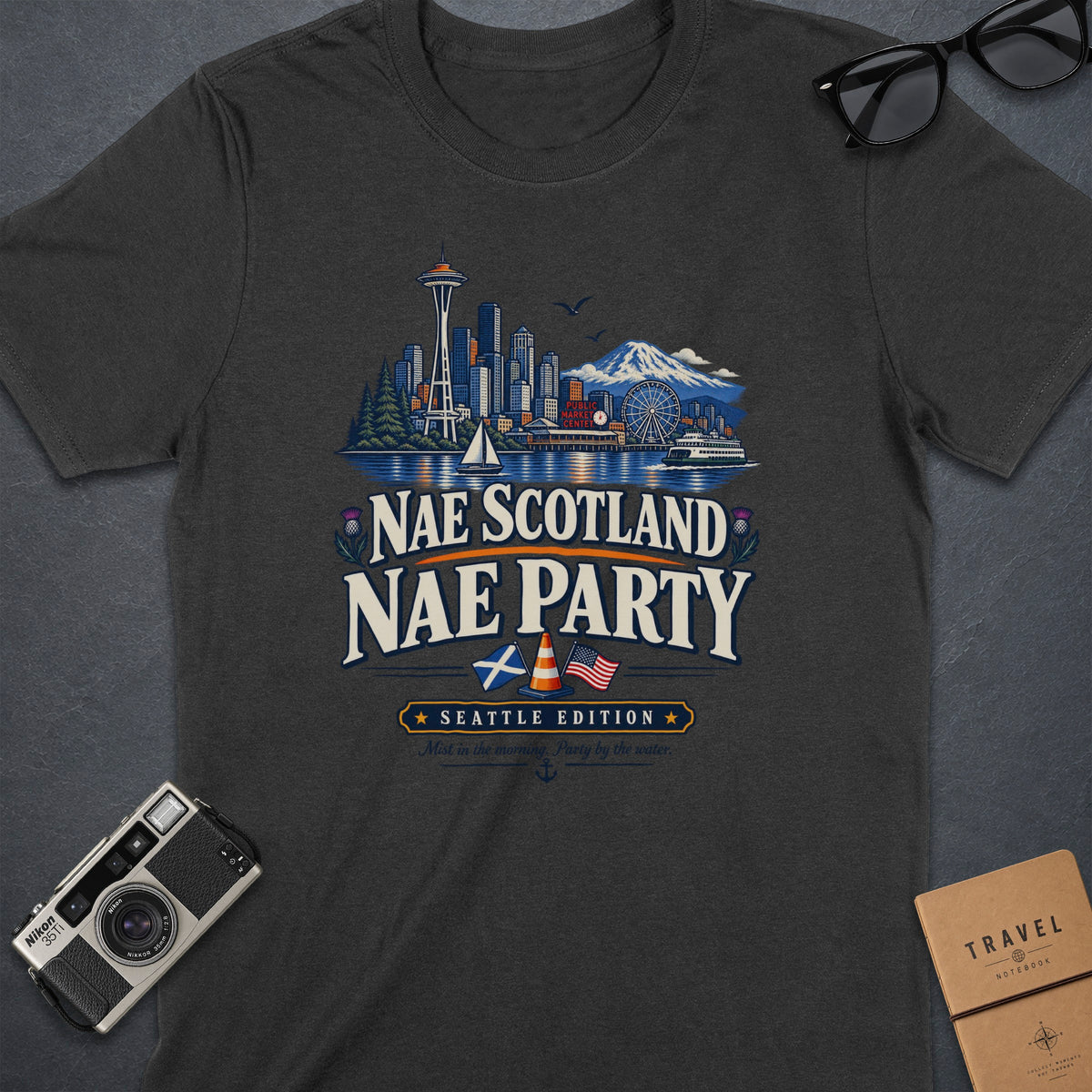 Dark t-shirt with Seattle skyline, "Nae Scotland Nae Party Seattle Edition" text, and thistle.