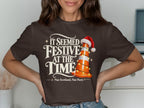 Brown t-shirt with "It Seemed Festive At The Time" and a traffic cone.