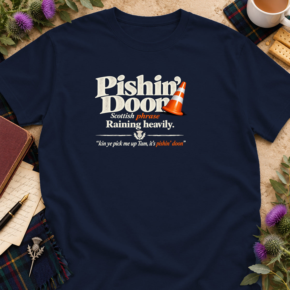 Dark navy t-shirt featuring white text that reads Pishin Doon, Scottish phrase, and Raining heavily.