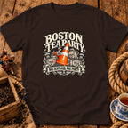 Dark brown t-shirt featuring a graphic with a traffic cone, tea crates, and text reading Boston Tea Party Nae Scotland, Nae Party.