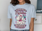 Light blue t-shirt with "Groomed to Perfection Behaved by Accident" and a poodle illustration.