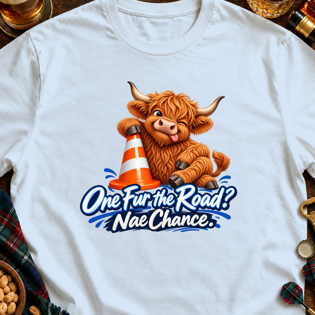 Cartoon Highland cow winks with tongue out, leaning on traffic cone, text "One Fur the Road? Nae Chance."