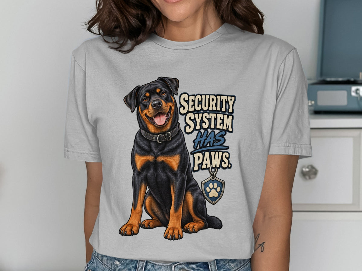 Rottweiler graphic with text "SECURITY SYSTEM HAS PAWS" on a gray t-shirt.
