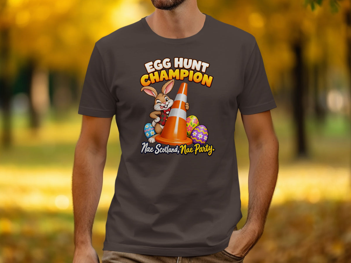 Brown t-shirt with cartoon rabbit, traffic cone, and Easter eggs. "Egg Hunt Champion Nae Scotland, Nae Party."