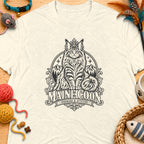 Cream t-shirt with a black graphic of a crowned Maine Coon cat, mountains, and text.