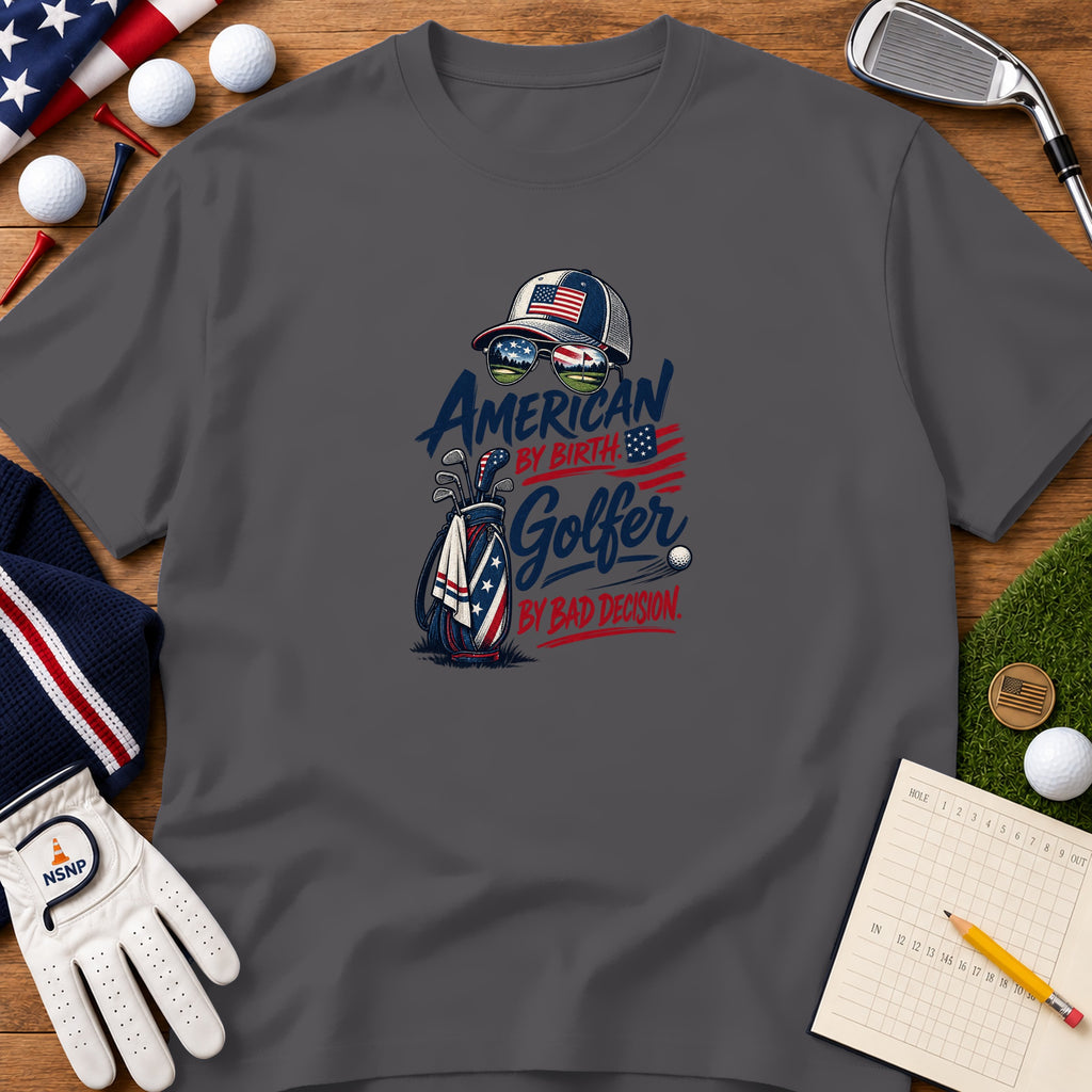 Dark gray t-shirt featuring a patriotic golf graphic, surrounded by golf balls, tees, and accessories on wood.