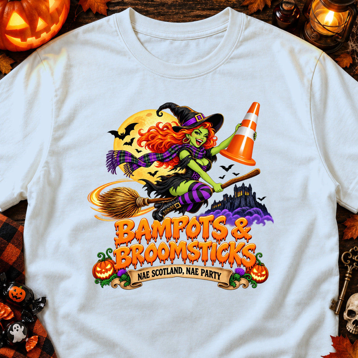 Witch with traffic cone on broomstick flying past haunted castle with text "Bampots & Broomsticks".