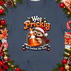 Hedgehog wearing Santa hat hugs traffic cone with text "Wee Prickly" and "Nae Scotland, Nae Party."