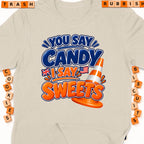 Graphic tee with "You Say Candy, I Say Sweets" text, traffic cone and flags.
