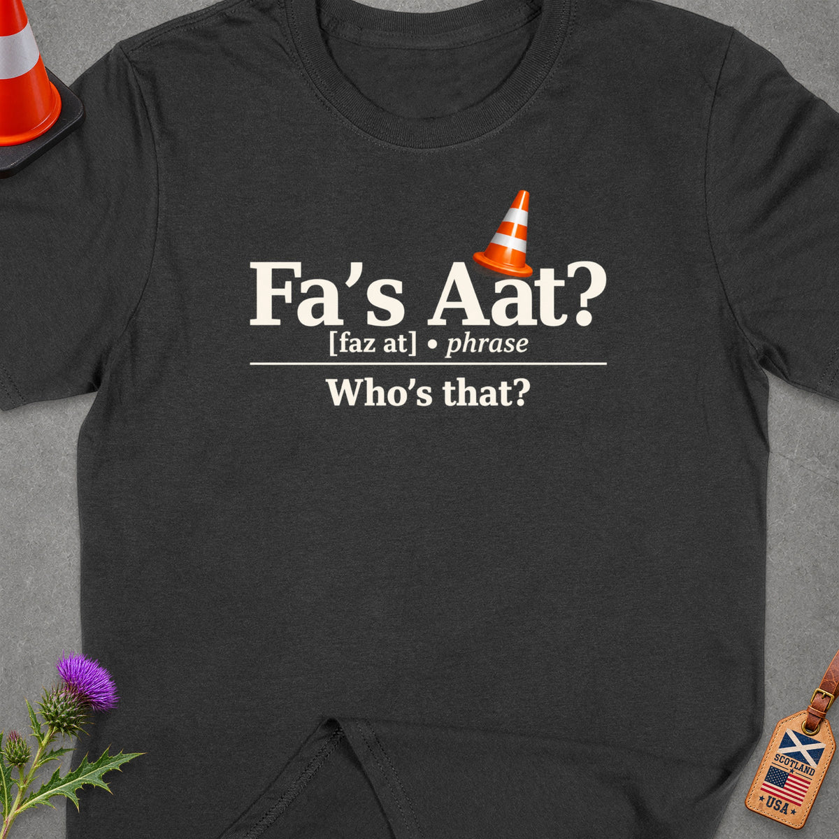 Dark t-shirt with text "Fa's Aat? Who's that?" and traffic cone graphic.