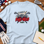 Light blue t-shirt featuring a golf graphic with crossed clubs, a scorecard, and the text The Scorecard Is Fake News.