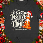 Dark t-shirt with text "It Seemed Festive At The Time Nae Scotland, Nae Party." and a traffic cone.