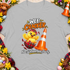Chick hatching from a tartan egg near a traffic cone, text "Wee Cracker".