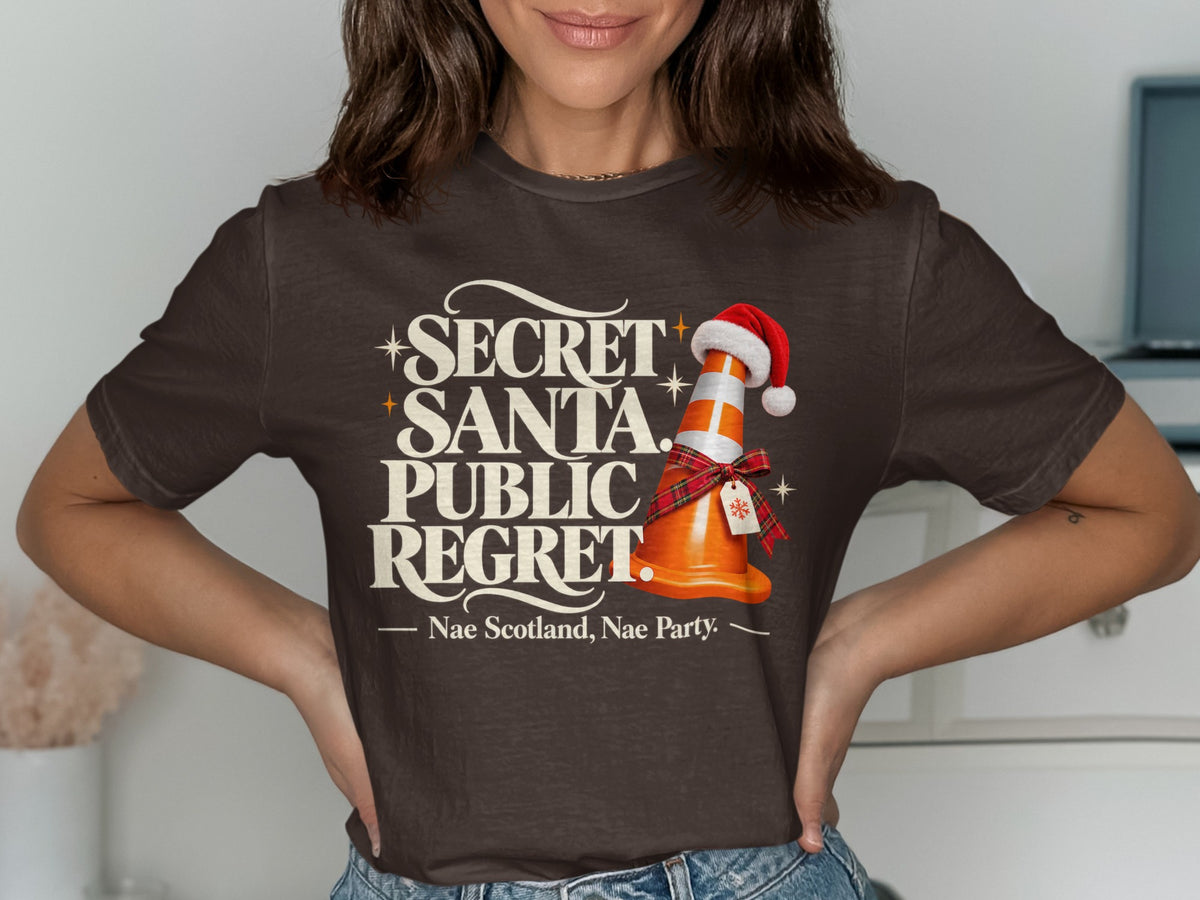 T-shirt with "Secret Santa Public Regret" and a traffic cone wearing a Santa hat.
