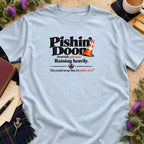 A light blue t-shirt printed with the Scottish phrase Pishin Doon and a traffic cone graphic.