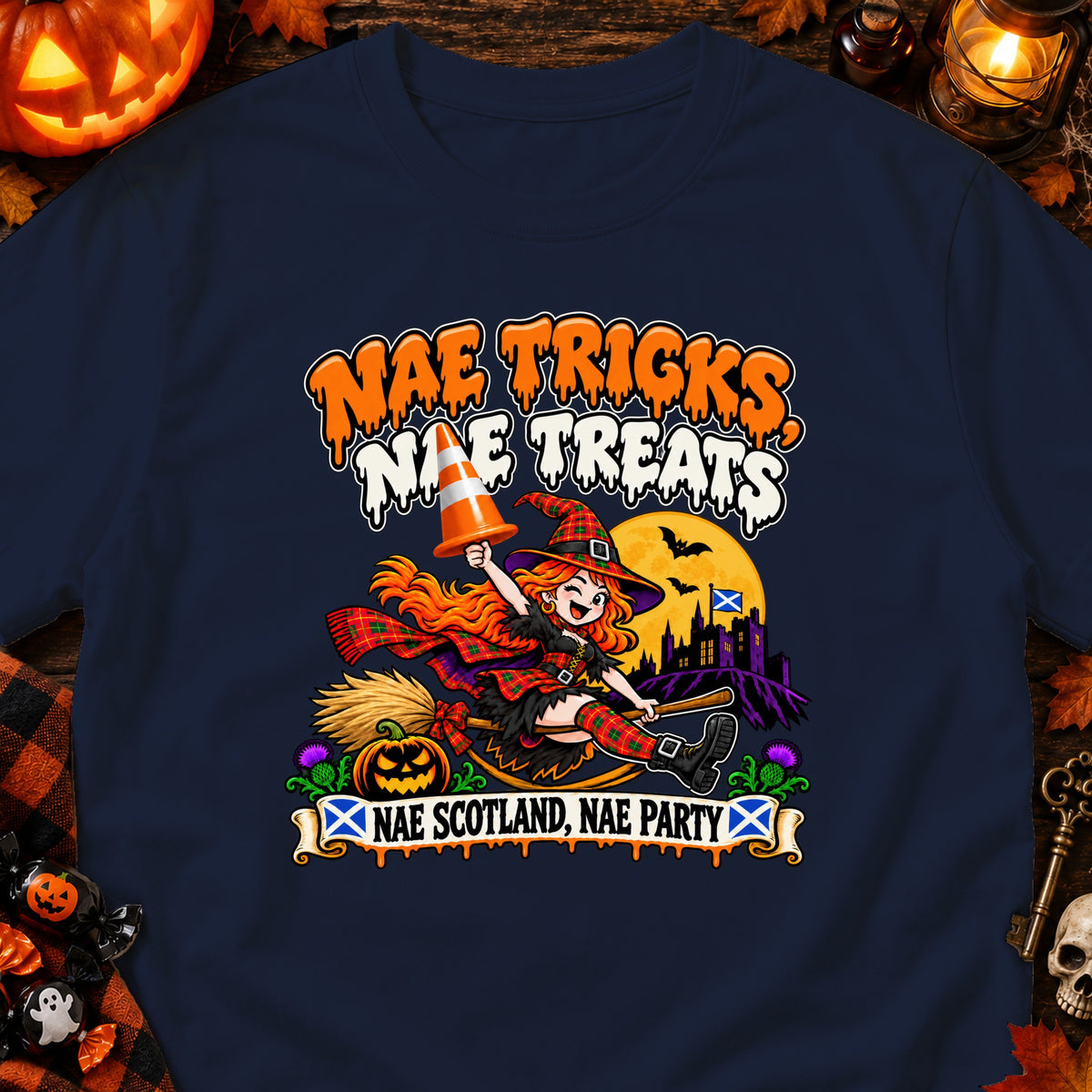 Halloween-themed t-shirt with witch, pumpkins, castle, Scottish flag and text.