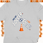 Light gray t-shirt with "You Say Soccer, I Say Football" graphic and traffic cone.