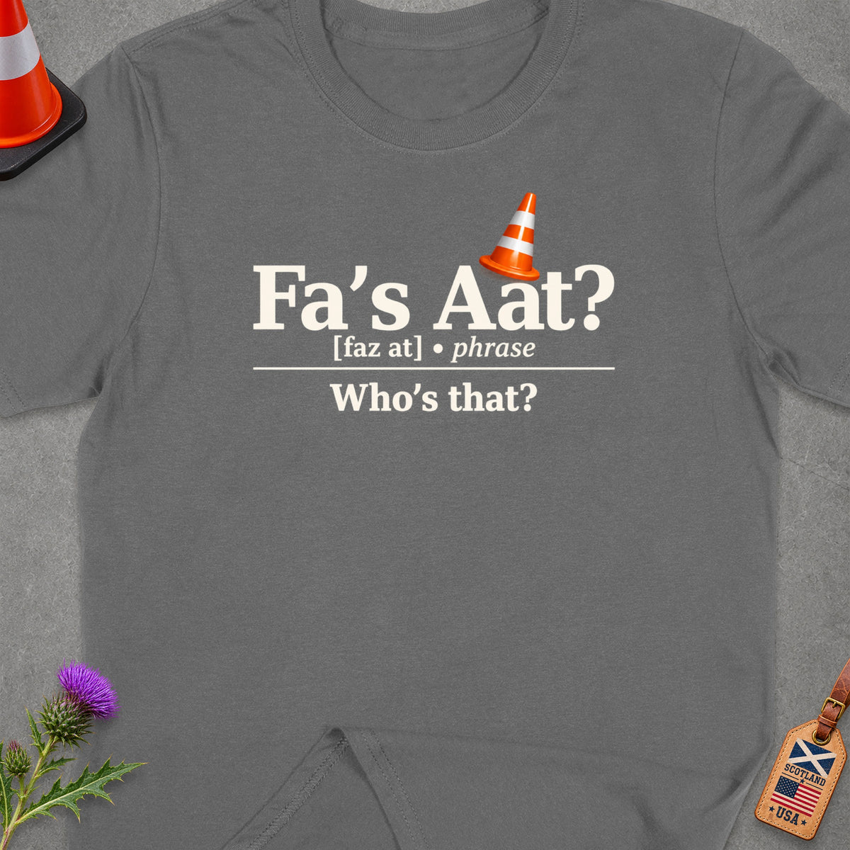 T-shirt with text "Fa's Aat? Who's that?", orange cone and Scottish thistle.