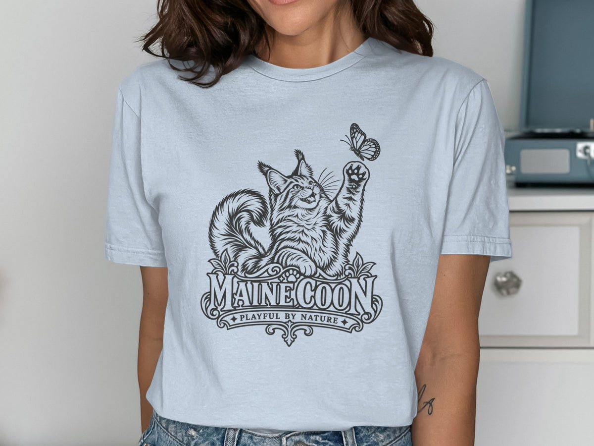 Light blue t-shirt with a black line drawing of a Maine Coon cat reaching for a butterfly.
