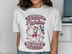 White t-shirt with a cartoon poodle holding a comb and text "GROOMED TO PERFECTION".