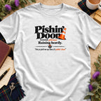 White t-shirt featuring black text reading Pishin' Doon, Scottish phrase Raining heavily, and an orange traffic cone.